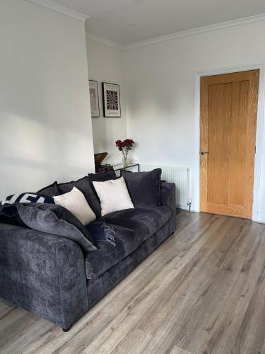 Una sala de estar con un sofá y suelo de madera. en Sheffield Contemporary Elegant Getaway, en Wincobank