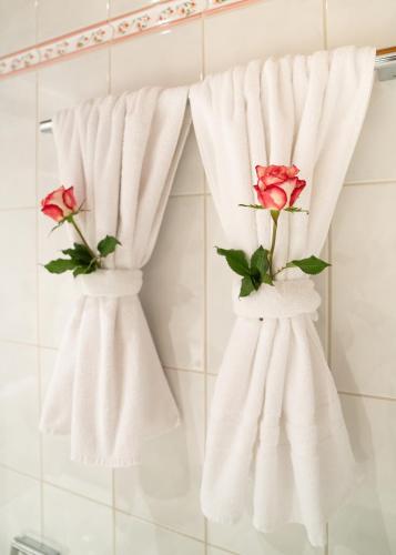 two towels with roses on them hanging in a bathroom at Hotel Krone Tirol in Reutte