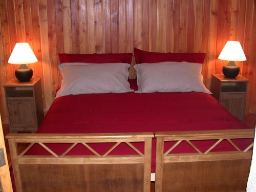a bedroom with a red bed with two lamps at Baita Amiata in Monte Amiata