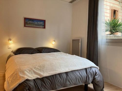 une chambre avec un lit dans une pièce avec une fenêtre dans l'établissement Appartement cosy et calme en cœur de ville - Quartier Saint Aubin proche gare, à Toulouse