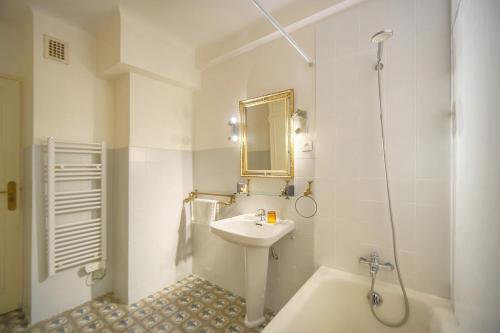 une salle de bain blanche avec un lavabo et une baignoire dans l'établissement FRGK Rochelongue Vue Mer Panoramique, Terrasse & Plage Privée, à Cannes