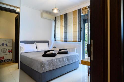 a bedroom with a bed with two black towels on it at Athenian Riviera Prestige 2 bedroom in Athens