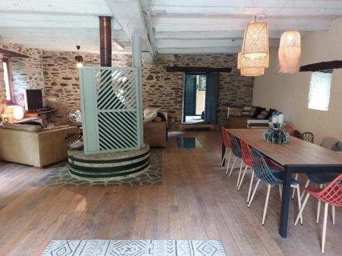 un salon avec une table et des chaises dans l'établissement Moulin de serre, à Cassagnes-Bégonhès