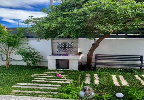 a bench sitting next to a wall with a tree at 1922 Epoch Harmony Oikia in Volos
