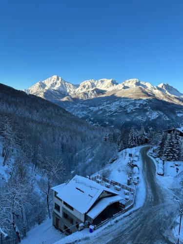 a building in the snow with mountains in the background at Miramonti Bellevue in Sauze dʼOulx