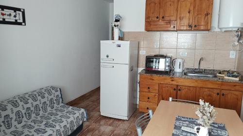 a kitchen with a white refrigerator and a table at Departamentos Pachamama in Tunuyán