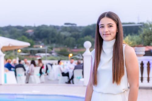 a woman in a white dress standing next to a pool at Villa Ennio in Ciampino