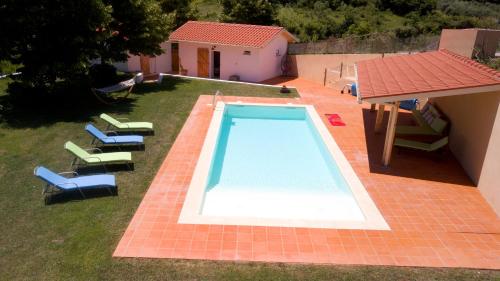 an overhead view of a swimming pool with chairs and a house at Casa do Moinho Rural Retreat in Podentes