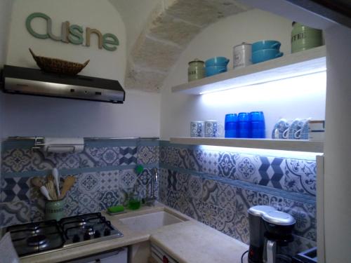 a kitchen with blue and white tiles on the wall at La chiave di Philoxenia in Ostuni