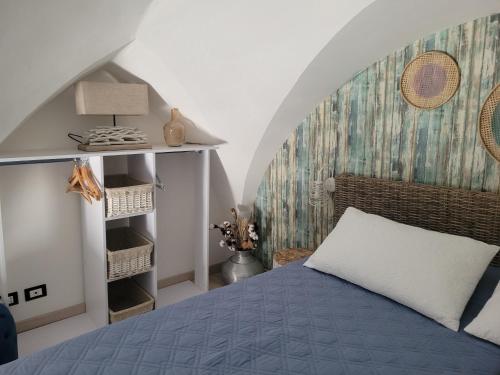 a bedroom with a blue bed and a wall at La chiave di Philoxenia in Ostuni