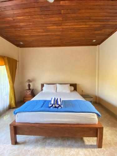 a bedroom with a large bed with a wooden ceiling at Villa Indah Anugrah in Kubu