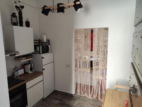 a kitchen with a refrigerator and a window with a curtain at Locazione Gattapone 3 all'angoletto in Gubbio