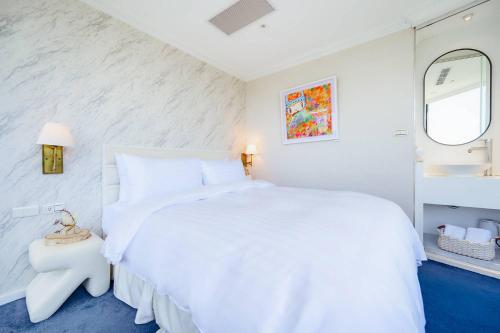 a white bedroom with a white bed and a mirror at 苓旅松山館 Lininn Tapei Arena in Taipei
