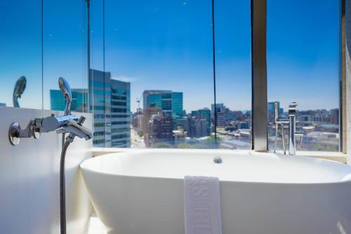 a bath tub in a bathroom with a large window at 苓旅松山館 Lininn Tapei Arena in Taipei