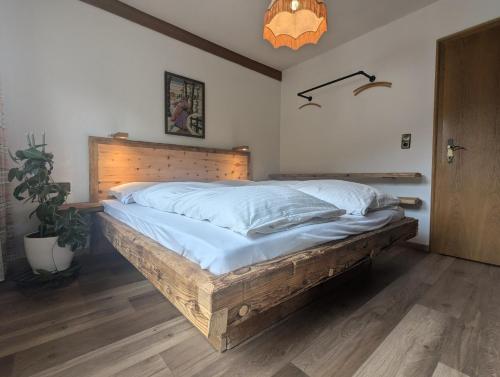 a bedroom with a large bed with a wooden headboard at Bergfreund in Lermoos