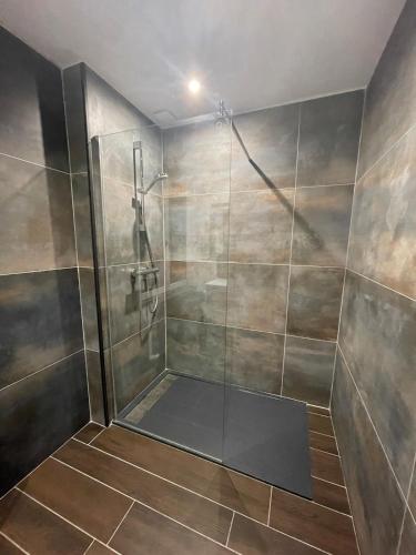a shower with a glass door in a bathroom at Lysgaard Cosy Cottage in La Bresse