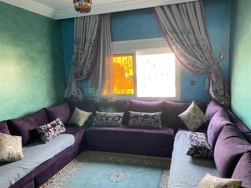 a purple couch in a living room with a window at Un appartement haut de gamme in Agadir