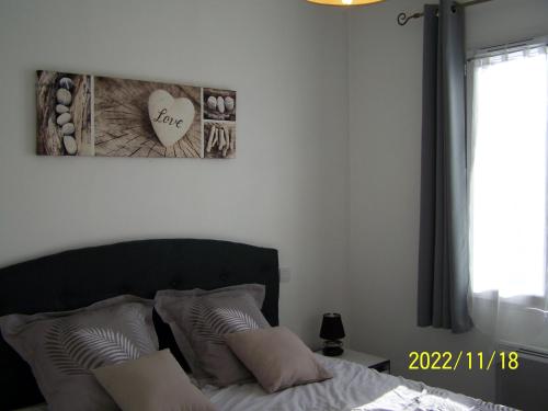 une chambre avec un lit et un tableau au mur dans l'établissement maisonlazenitude-lapalmyre, aux Mathes