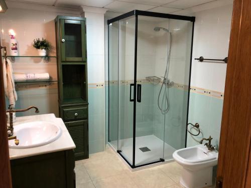 a bathroom with a glass shower and a sink at La Colonia Beach House in Águilas
