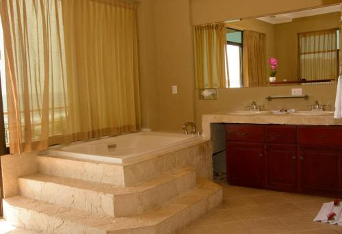 y baño con bañera, lavamanos y bañera. en Balcon del Mar Beach Front Hotel, en Jacó