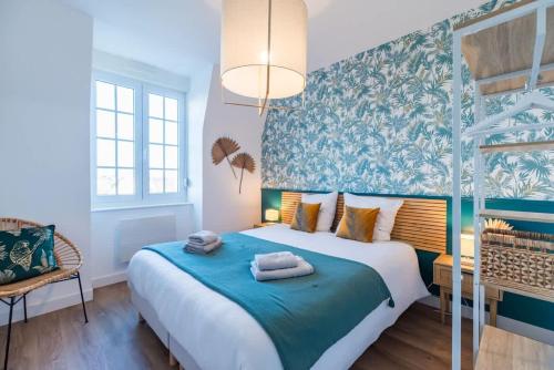 a bedroom with a large bed with blue and green wallpaper at Escapade a Tregastel plages et commerces proches in Trégastel