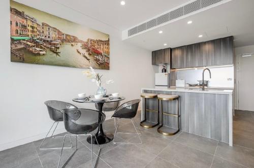 a kitchen with a table and chairs and a sink at The Elegant Deco Apartment World class building in Sydney