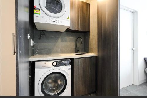 a kitchen with a washing machine and a microwave at The Elegant Deco Apartment World class building in Sydney