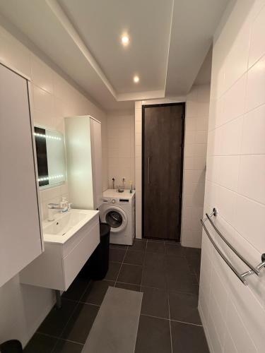 a bathroom with a sink and a toilet and a door at Gateway to Amsterdam in Almere