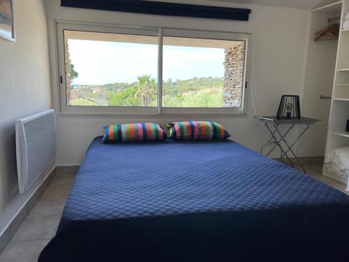 une chambre avec un grand lit avec une grande fenêtre dans l'établissement Mazet les Issambres, Sainte Maxime, aux Issambres