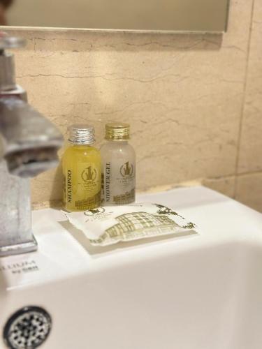 two bottles of yellow liquid sitting on top of a sink at 1 Million Hotel in Johor Bahru