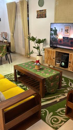 a living room with a coffee table and a television at Wana house wanagiri munduk bali in Gitgit