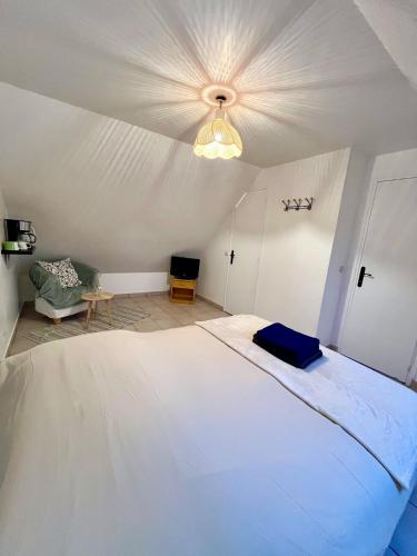 une chambre avec un grand lit blanc avec un plafond dans l'établissement Les gîtes du Mesnil chambre deluxe, à Équemauville