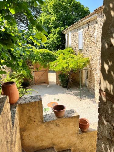 une vue extérieure d'une cour avec des plantes en pot dans l'établissement Mas avec piscine à 20 minutes du Pont du Gard, à Tresques