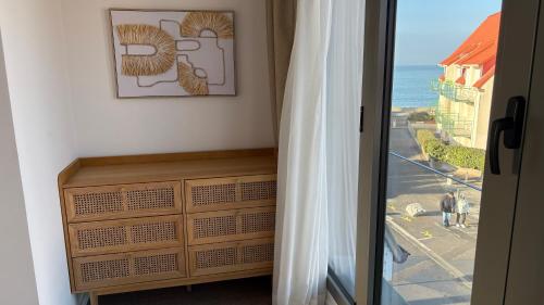 a door to a room with a view of the ocean at Logis- Hôtel de la Baie de Wissant & Appartements in Wissant
