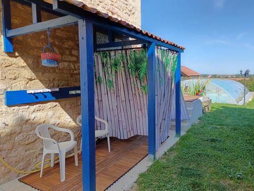 a gazebo with a table and chairs on a deck at Chambres d'hôtes piscine couverte & chauffée in Bouquemont