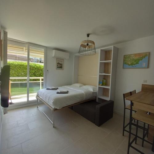 une chambre avec un lit, une table et une fenêtre dans l'établissement Très beau T2 4 personnes 200 m plage de la Favière, à Bormes-les-Mimosas