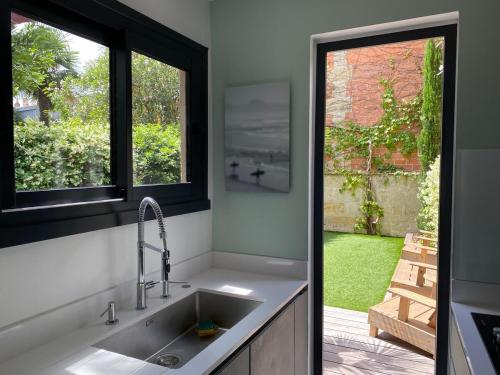 une cuisine avec un évier et une fenêtre dans l'établissement StSeurin Croix Blanche maison familiale en pierre, à Bordeaux