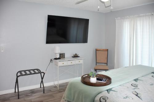 a bedroom with a bed and a tv on the wall at Lanai and Pond at Tranquil Bradenton Retreat! in Bradenton