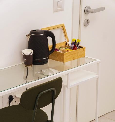 un escritorio con una taza y un hervidor de agua. en Loveinsky Tel Aviv rooms, en Tel Aviv