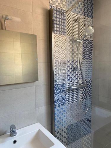 une salle de bain avec une douche avec un lavabo et un miroir dans l'établissement Joli studio tout équipé, à Oullins