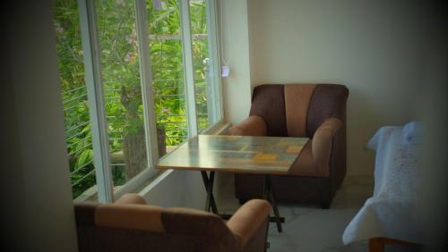 SaraTUBURAN Poolside的客房设有桌子、椅子和窗户。