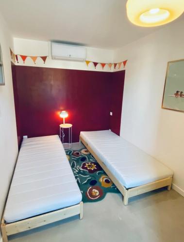 une chambre avec deux lits et une table avec une lampe dans l'établissement Charmante petite maison, à Hourtin