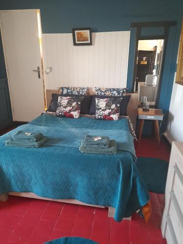 a bedroom with a bed with a blue comforter at Marie-Claire la grillade in Briare
