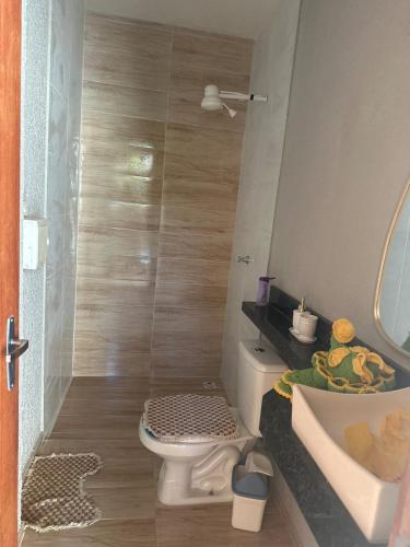 a small bathroom with a toilet and a sink at Aconhego Dourado I Alugue casa com piscina a 17min da praia in Parnaíba