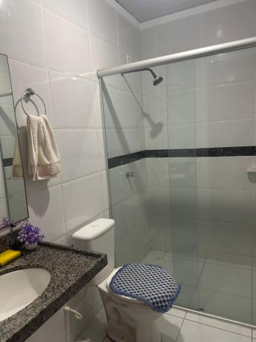 a bathroom with a shower and a toilet and a sink at Aconhego Dourado I Alugue casa com piscina a 17min da praia in Parnaíba