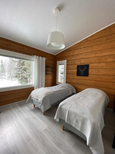 a bedroom with two beds and a window at Villa beach star in Ranua