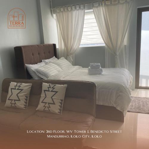 una camera con letto e divano con cuscini di Terra Condo a Città di Iloilo