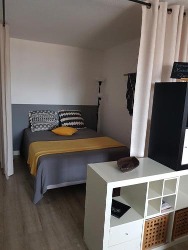 sypialnia z łóżkiem i telewizorem w obiekcie MARSEILLAN-PLAGE Appartement Coeur de sable w mieście Marseillan