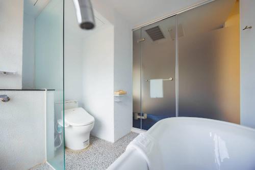 a bathroom with a tub and a toilet and a shower at 苓旅松山館 Lininn Tapei Arena in Taipei