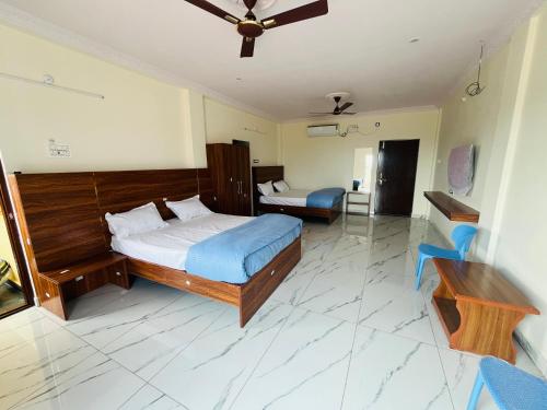 a bedroom with a bed and a desk in it at Blue Waves Beach Resort in Vetāpālem